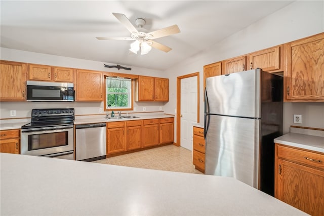 kitchen with light tile patterned flooring, ceiling fan, stainless steel appliances, sink, and vaulted ceiling