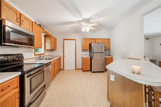 kitchen with sink, appliances with stainless steel finishes, light tile patterned floors, and ceiling fan