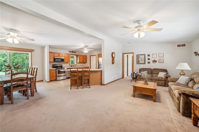 carpeted living room featuring ceiling fan