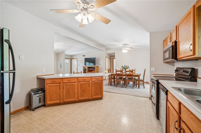 kitchen featuring beam ceiling, light tile patterned floors, kitchen peninsula, ceiling fan, and stainless steel appliances