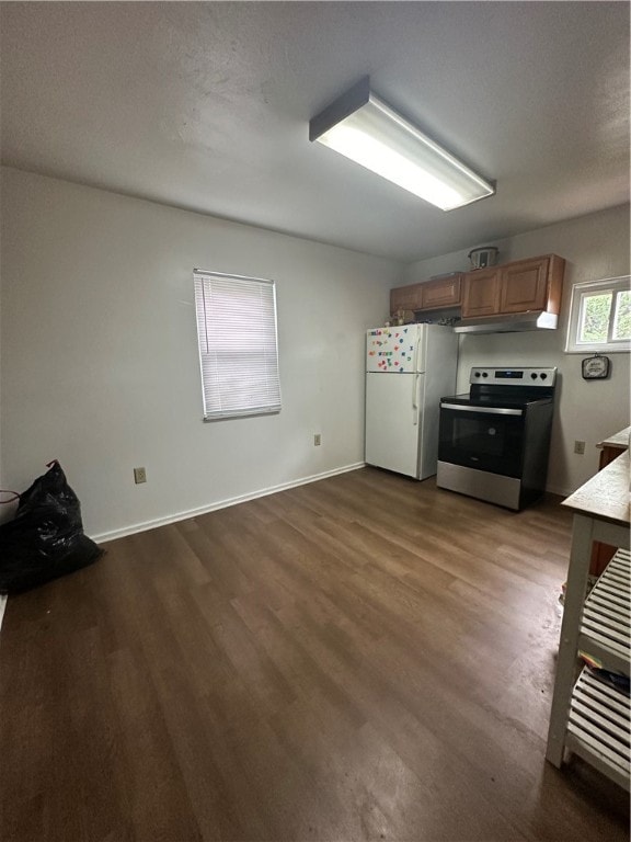 kitchen with wood-type flooring, stainless steel electric range, and white fridge