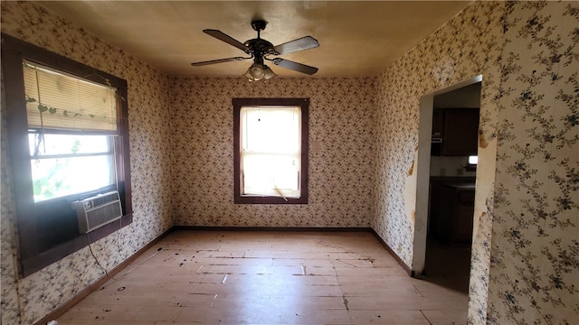 unfurnished room featuring cooling unit, light wood-type flooring, and ceiling fan