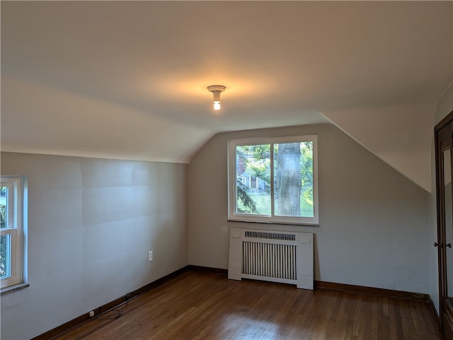 bonus room featuring vaulted ceiling, dark hardwood / wood-style flooring, and radiator heating unit