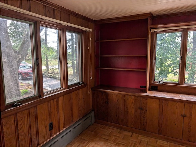 unfurnished sunroom featuring baseboard heating and a healthy amount of sunlight