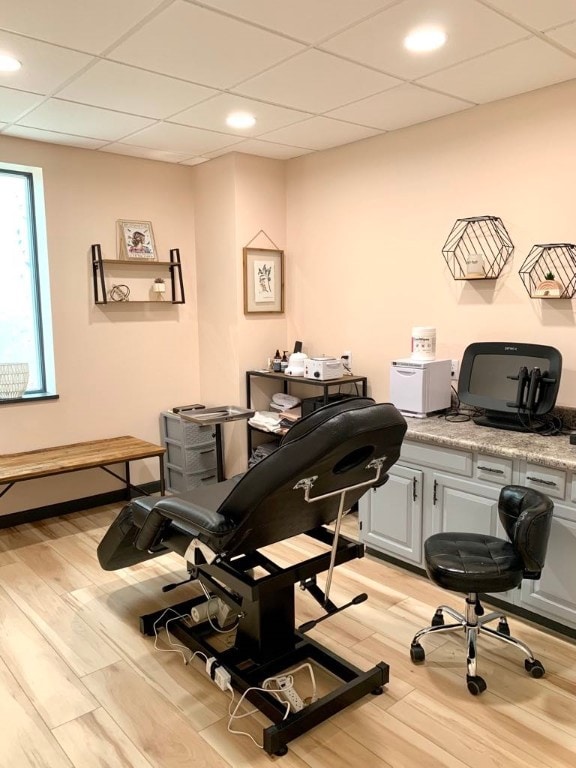 office with light hardwood / wood-style flooring and a paneled ceiling