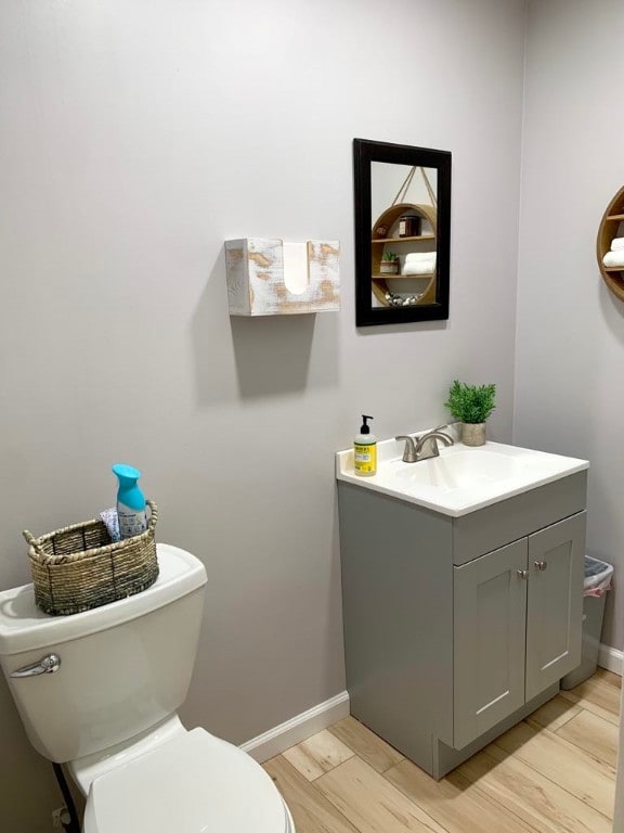 bathroom featuring vanity, wood-type flooring, and toilet