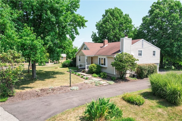 view of front of house featuring central AC and a front yard