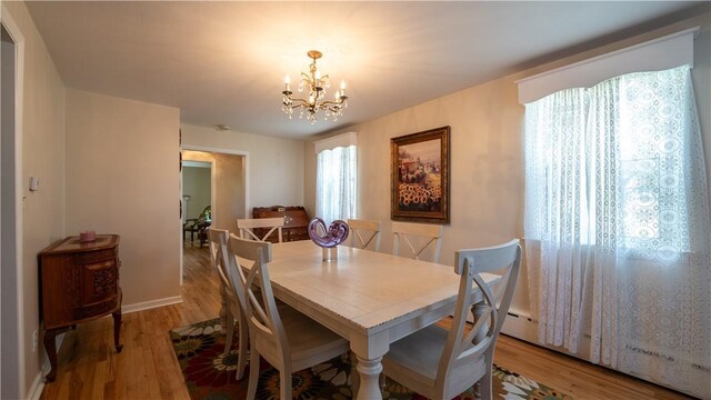 dining space with a notable chandelier and hardwood / wood-style floors