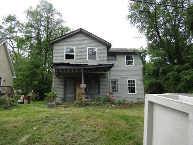 rear view of property featuring a lawn