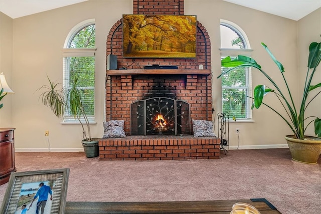 carpeted living room with a wealth of natural light, lofted ceiling, and a fireplace