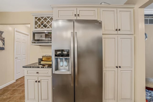 kitchen featuring dark stone countertops, tile patterned floors, and appliances with stainless steel finishes