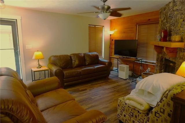 living room with ceiling fan, a fireplace, and wood finished floors