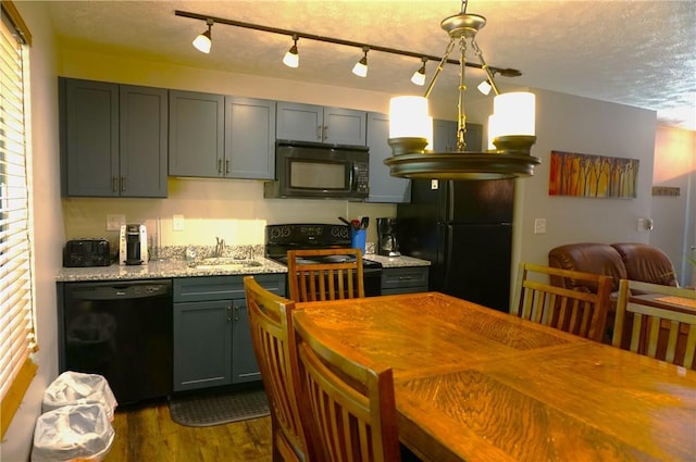 kitchen with dark wood-style flooring, gray cabinetry, a sink, a textured ceiling, and black appliances