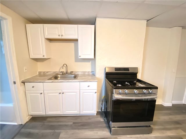 kitchen featuring sink, dark hardwood / wood-style floors, white cabinets, and stainless steel gas range oven