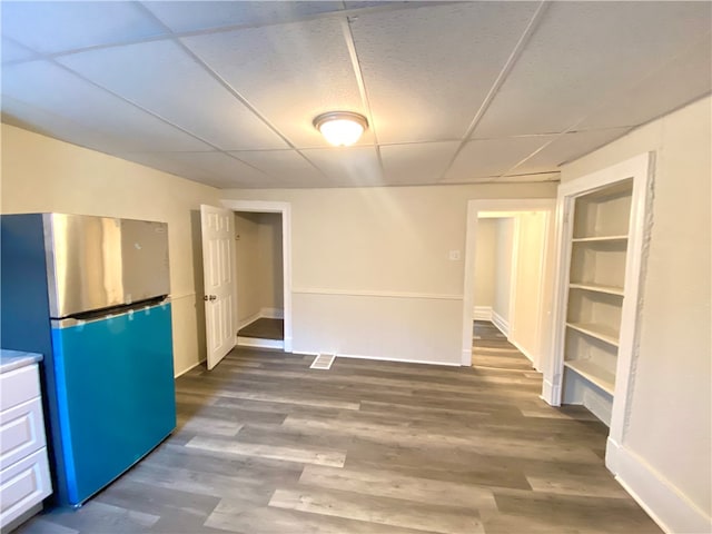 interior space with a paneled ceiling and wood-type flooring