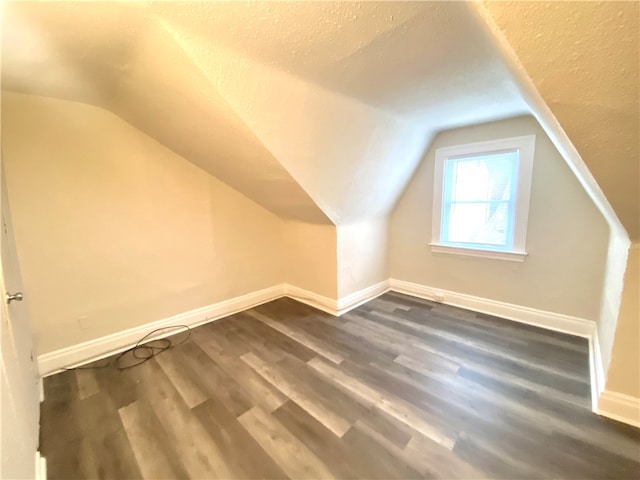 bonus room featuring a textured ceiling, hardwood / wood-style flooring, and vaulted ceiling