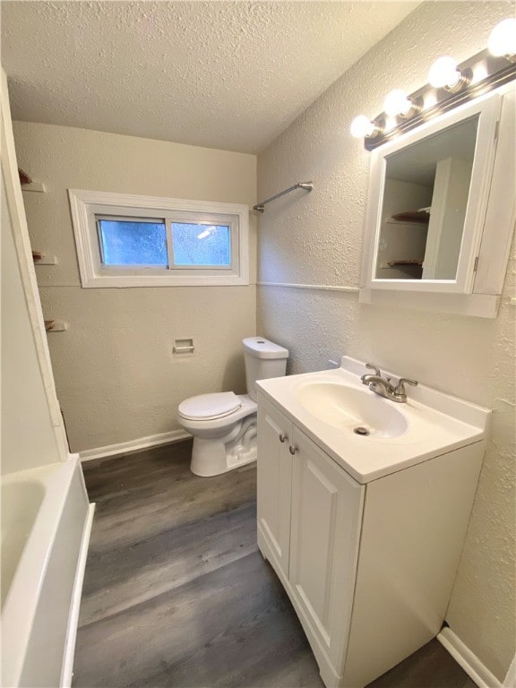 full bathroom featuring a textured ceiling, toilet, shower / tub combination, vanity, and hardwood / wood-style flooring