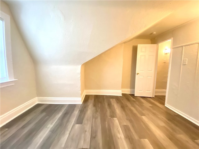 additional living space featuring hardwood / wood-style flooring and vaulted ceiling