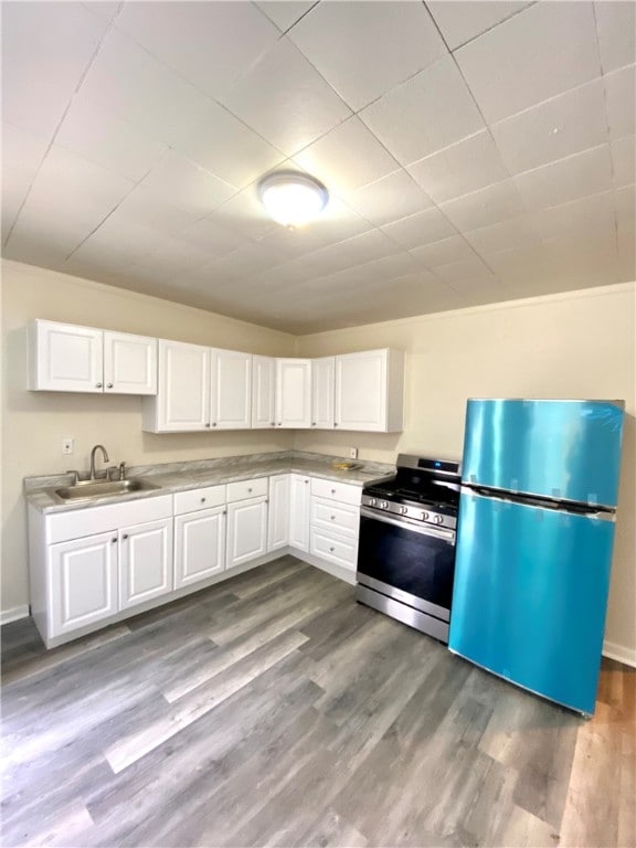 kitchen with white cabinetry, stainless steel appliances, hardwood / wood-style floors, and sink