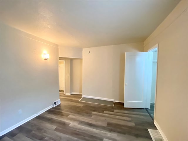 unfurnished room featuring dark hardwood / wood-style flooring