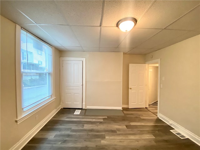 unfurnished bedroom with a drop ceiling and hardwood / wood-style floors