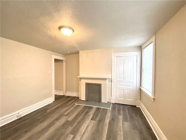 unfurnished living room with dark hardwood / wood-style floors and a textured ceiling