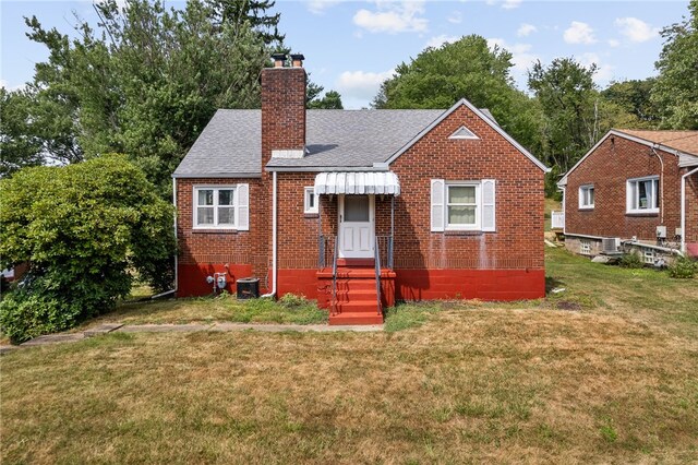 bungalow-style home featuring central AC and a front lawn