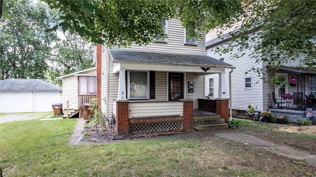 view of front of house with a garage, an outbuilding, a porch, and a front yard