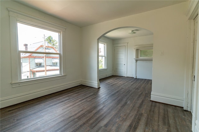 spare room with a baseboard radiator, dark hardwood / wood-style flooring, and a wealth of natural light