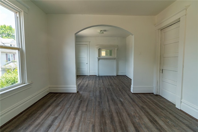 spare room with baseboard heating and dark hardwood / wood-style flooring