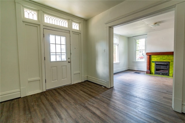 foyer with a fireplace, dark hardwood / wood-style floors, and a healthy amount of sunlight