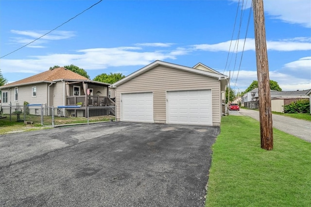 view of front facade featuring an outbuilding, a garage, and a front lawn