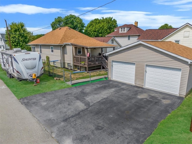 view of front of home with a garage, a deck, and a front yard