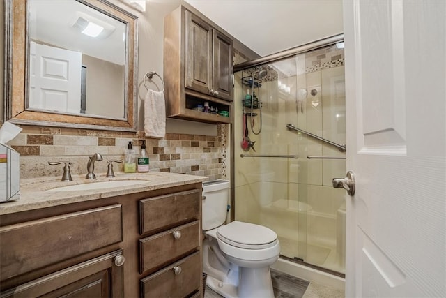 bathroom with backsplash, a shower with door, toilet, and vanity