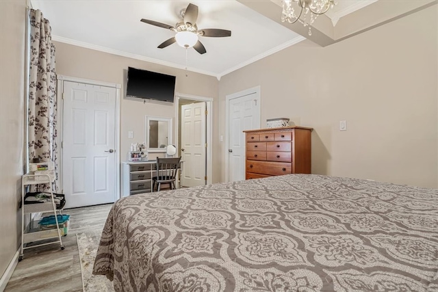 bedroom with ceiling fan with notable chandelier, light wood-type flooring, and ornamental molding