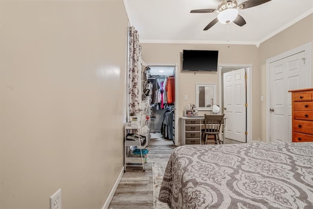 bedroom with ceiling fan, crown molding, a closet, and wood-type flooring