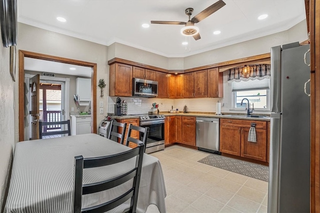 kitchen featuring sink, light tile patterned flooring, a healthy amount of sunlight, and stainless steel appliances