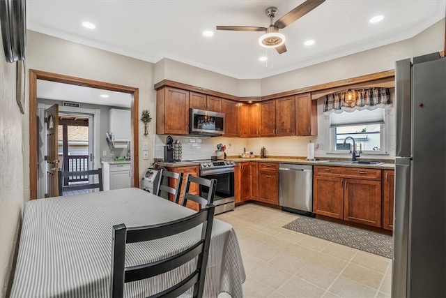 kitchen with ceiling fan, tasteful backsplash, stainless steel appliances, sink, and light tile patterned floors