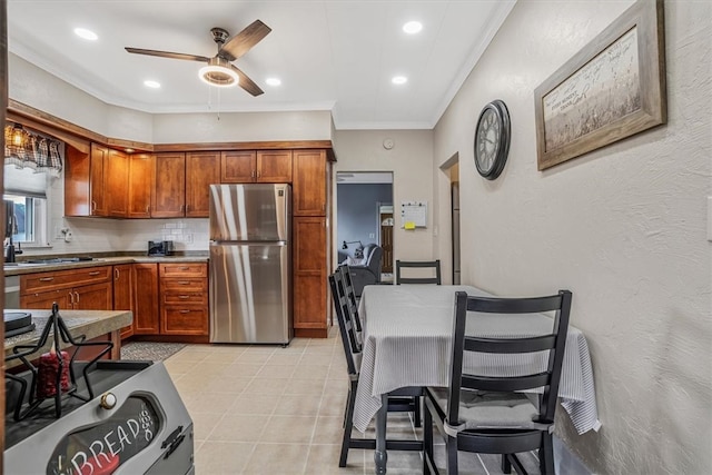 kitchen with stainless steel fridge, light tile patterned floors, decorative backsplash, ceiling fan, and ornamental molding