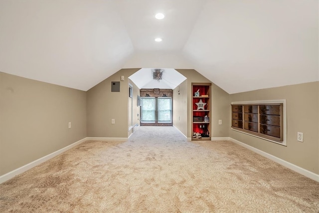 bonus room with light carpet, built in shelves, and lofted ceiling