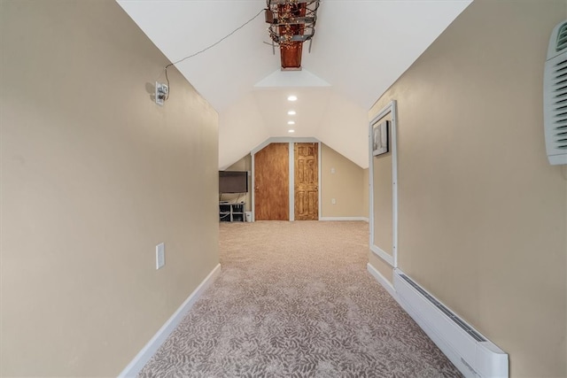 corridor featuring carpet floors, a baseboard heating unit, and lofted ceiling