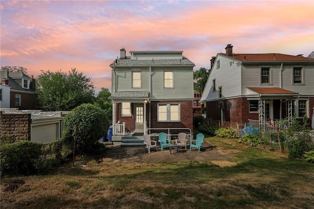 back house at dusk featuring a yard