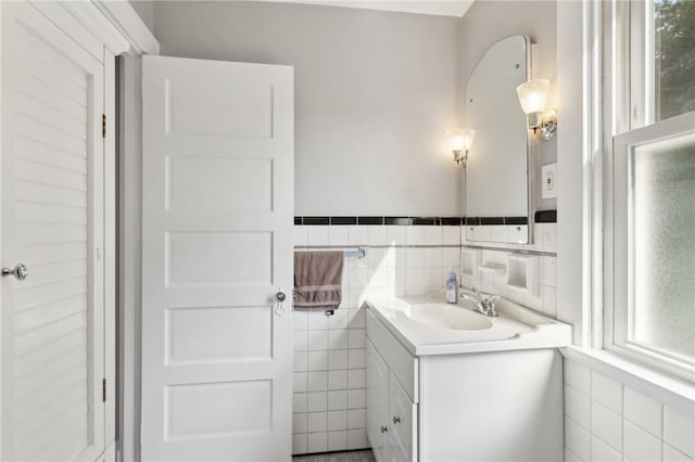 bathroom with vanity and tile walls