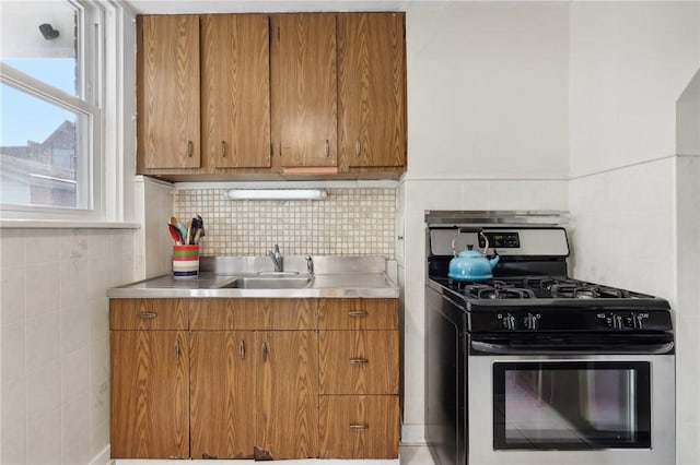 kitchen featuring sink, backsplash, and gas stove