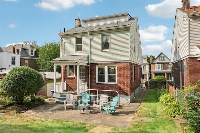 rear view of house with a patio and a yard