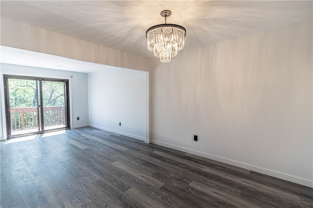 spare room with hardwood / wood-style flooring, a notable chandelier, and a textured ceiling