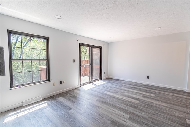 unfurnished room with a healthy amount of sunlight and wood-type flooring