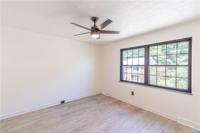 empty room with light hardwood / wood-style floors, a textured ceiling, and ceiling fan