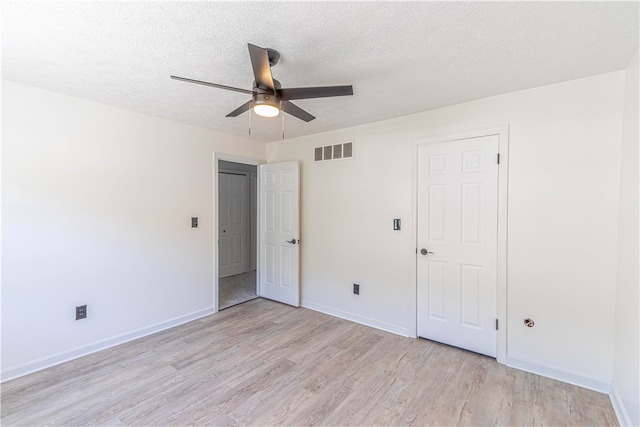 unfurnished bedroom featuring light wood-type flooring, ceiling fan, and a textured ceiling