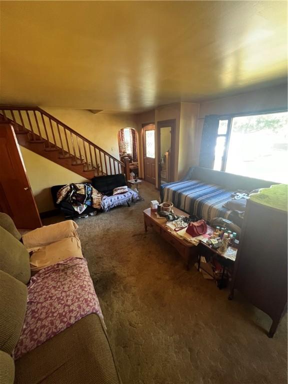 living room with carpet flooring and stairs